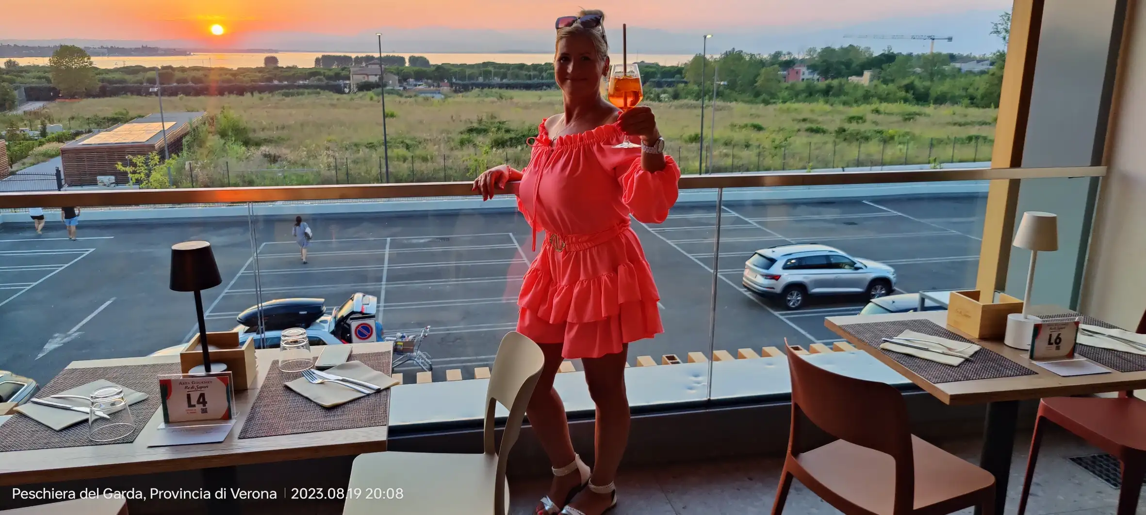 Žena Zdenka v šatech se sklenicí v ruce v restauraci